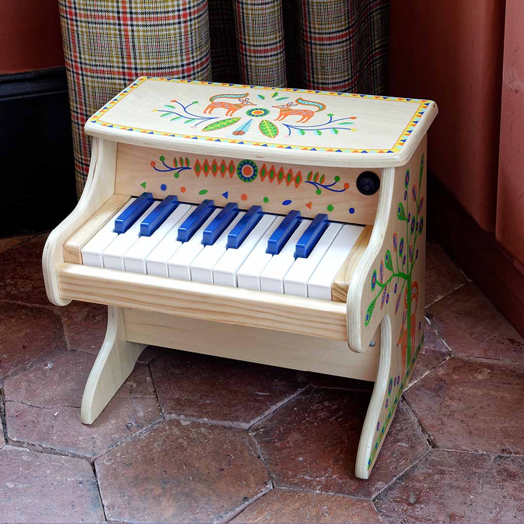 De Djeco elektronische piano met dier- en bladpatronen staat op een tegelvloer in een kamer.