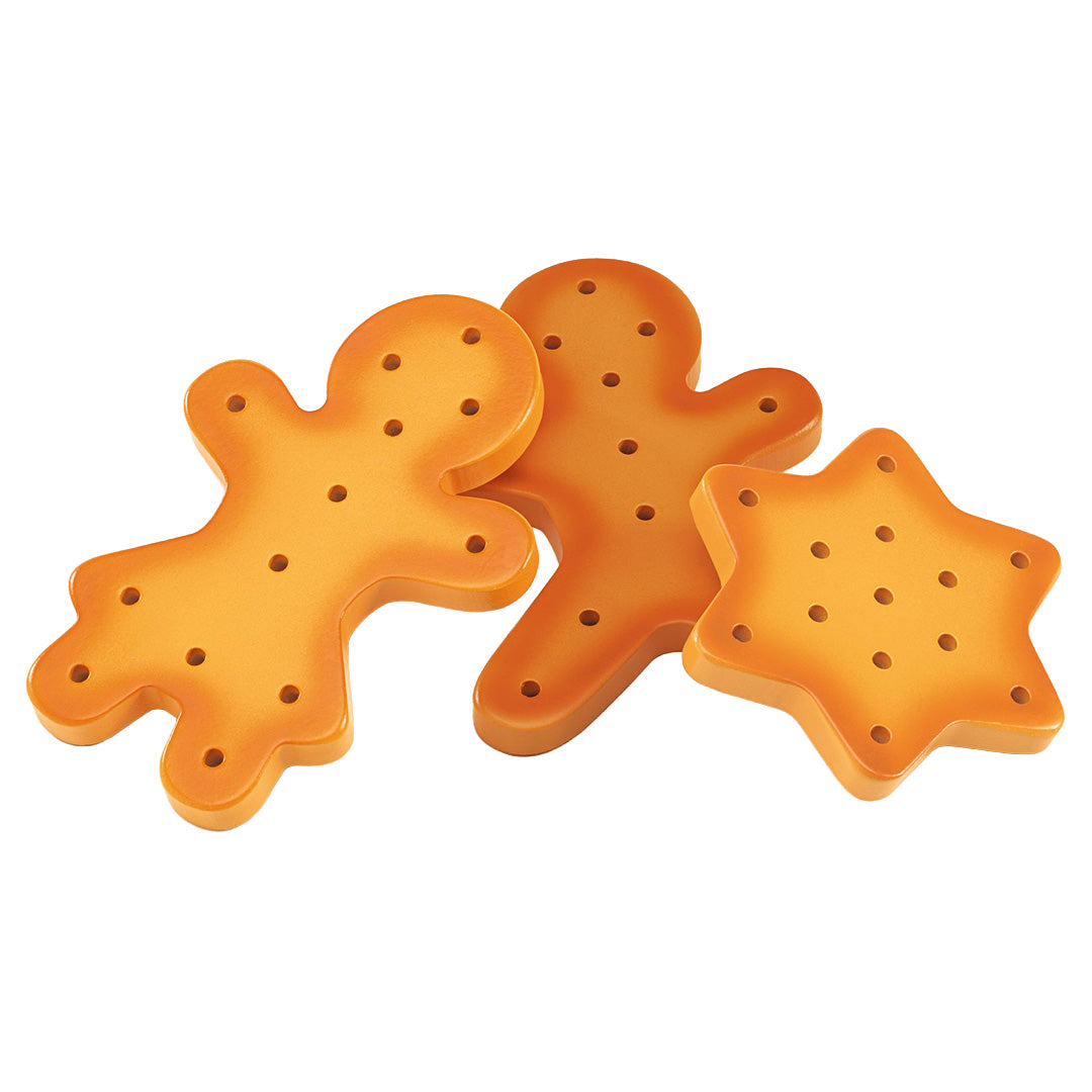 Drie onversierde oranje speelgoedkoekjes in de vorm van twee gingerbread mannen en een ster.