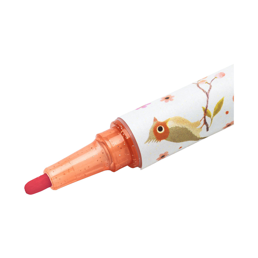 Detail van de punt van een glitterstift met een vogel- en bloemenpatroon.