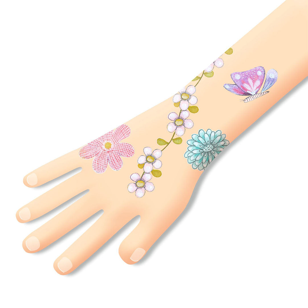 Een hand met aangebrachte tijdelijke tattoos van bloemen en een vlinder.