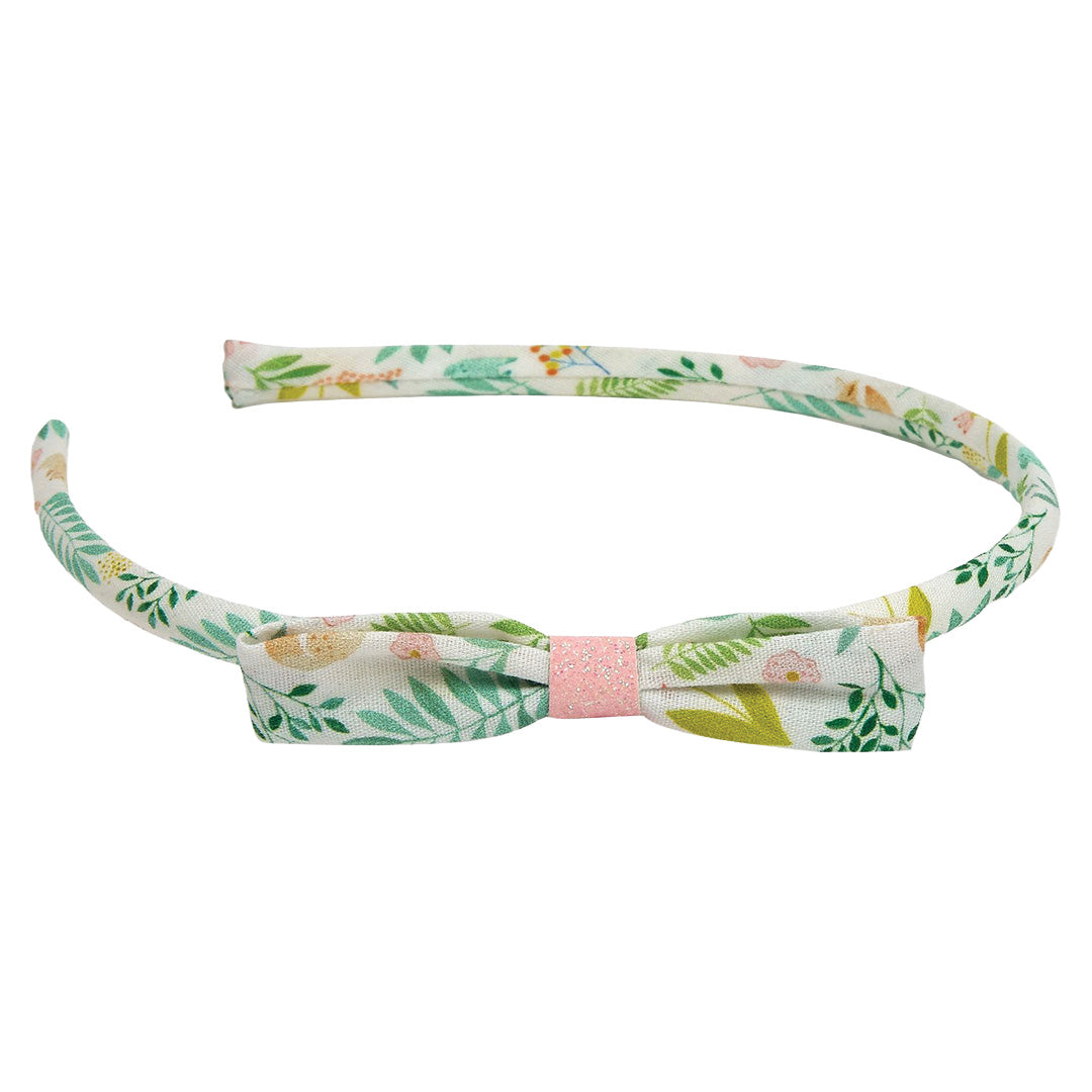 Djeco haarband met een gebloemd patroon van bladeren en bloemen, en een strik.