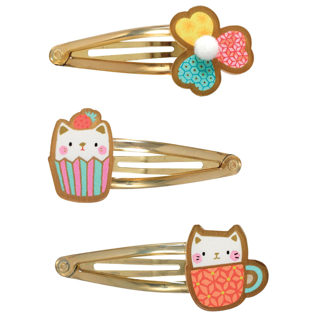 Drie Djeco haarspeldjes met een bloem, een kat in een cupcake en een kat in een mok.