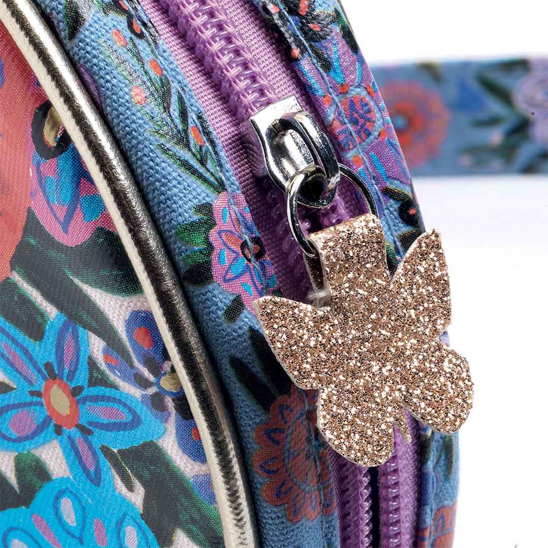 Detail van de rits van de kinderhandtas met een glitterende vlinder als ritstrekker.