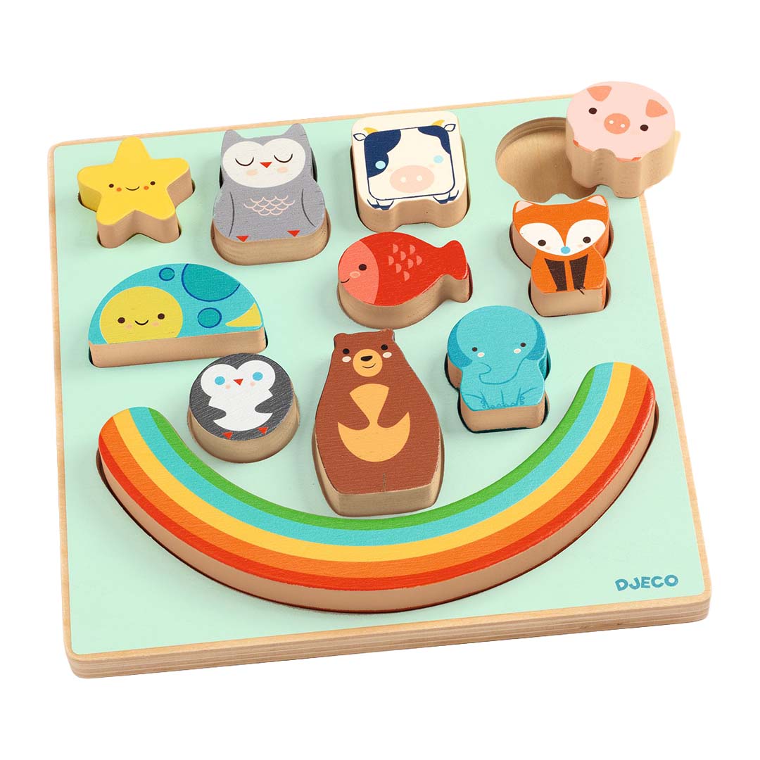 Djeco houten puzzelbord met een regenbooguitsparing en diverse dierenpuzzelstukken, met één varken ernaast.