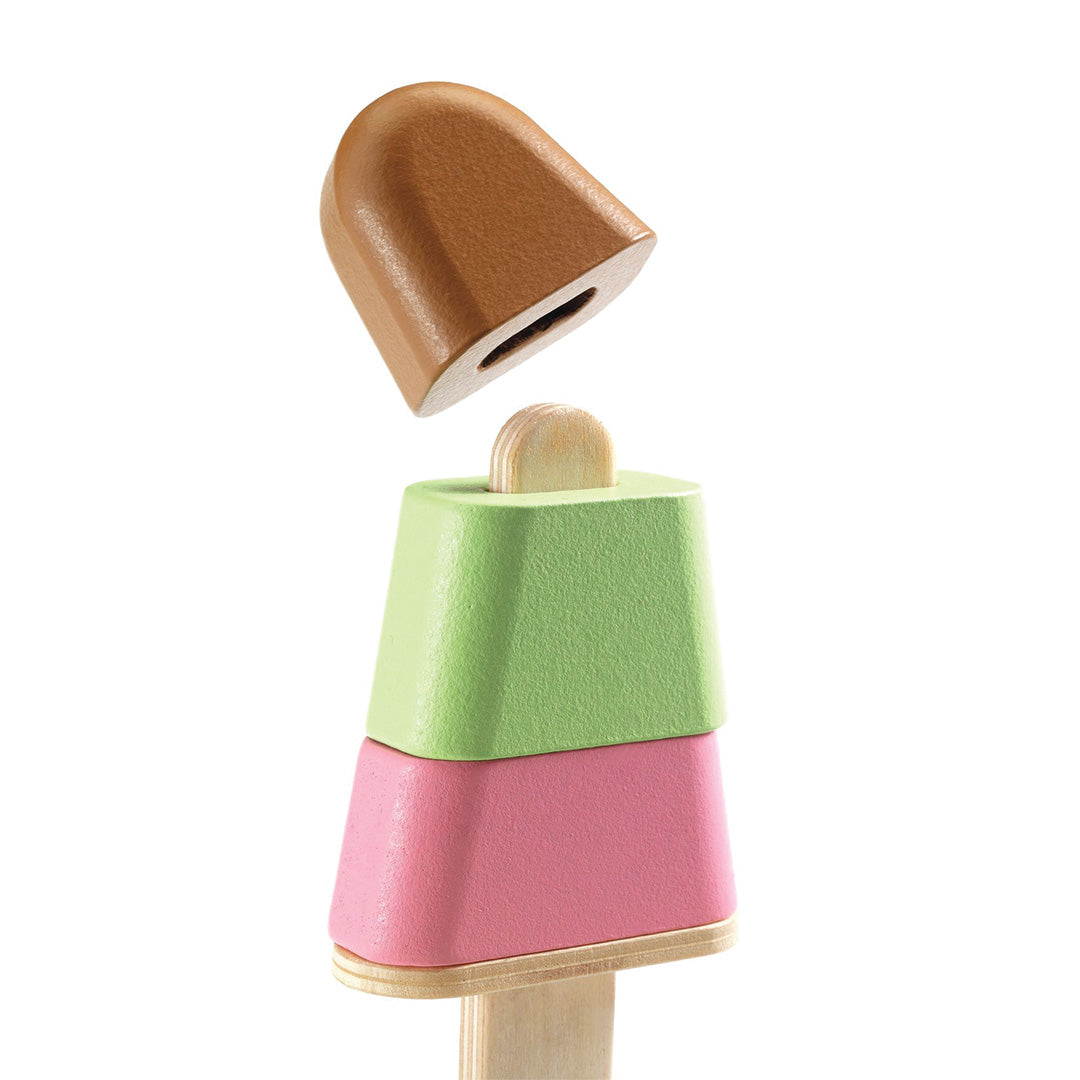 Detail van een houten popsicle met losse bruine, groene en roze delen en een houten stokje.