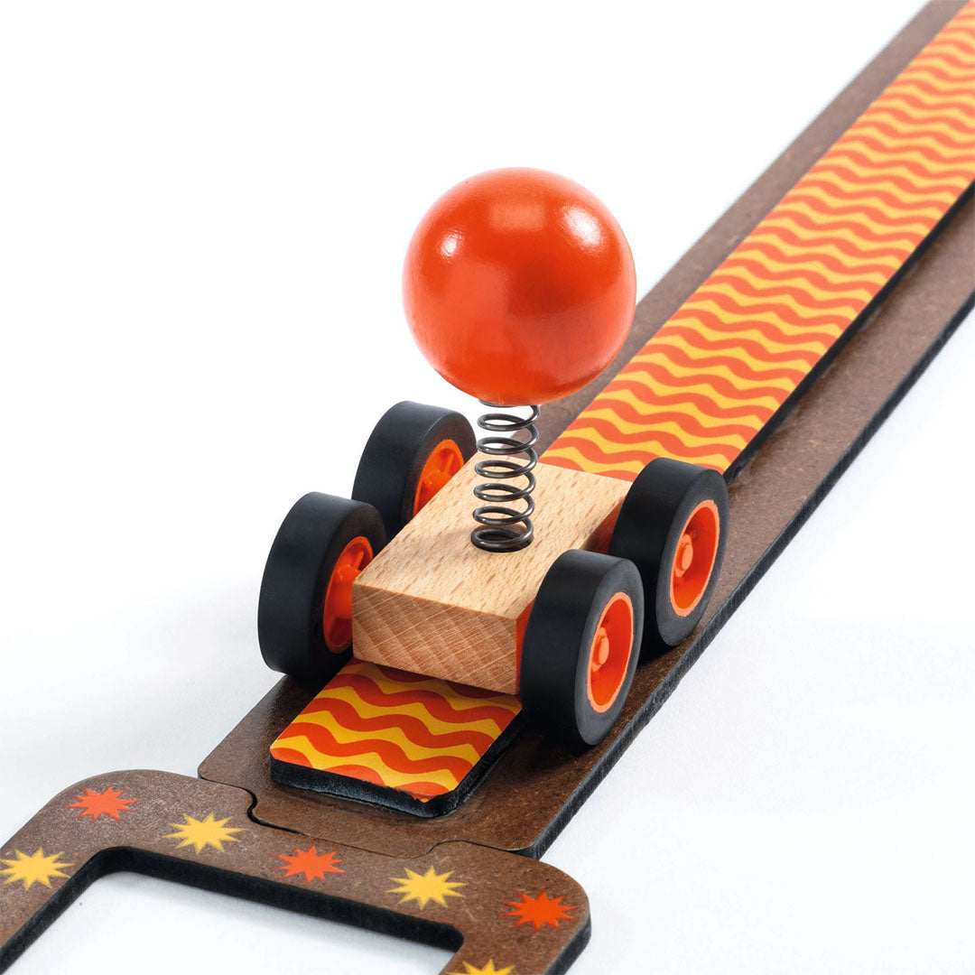 Detail van het Djeco Zig & Go Junior kettingreactiespel met een wagentje met een oranje bal op een veer.