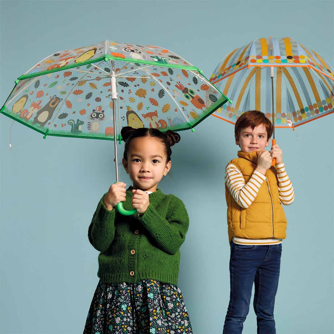 Twee kinderen met kinderparaplu's, waarvan één de Djeco kinderparaplu met bosdieren vasthoudt.