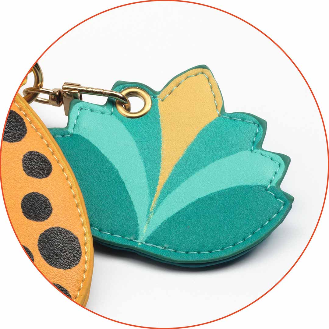 Detail van de groene en gele blad-hanger van de Djeco kinder crossbodytas.