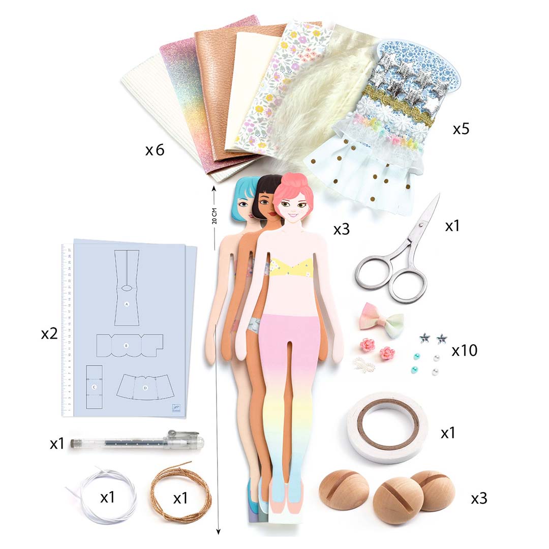 De complete inhoud van de Djeco knutselset 'La mode by Caroline' met drie poppen, stoffen, schaar en diverse accessoires.