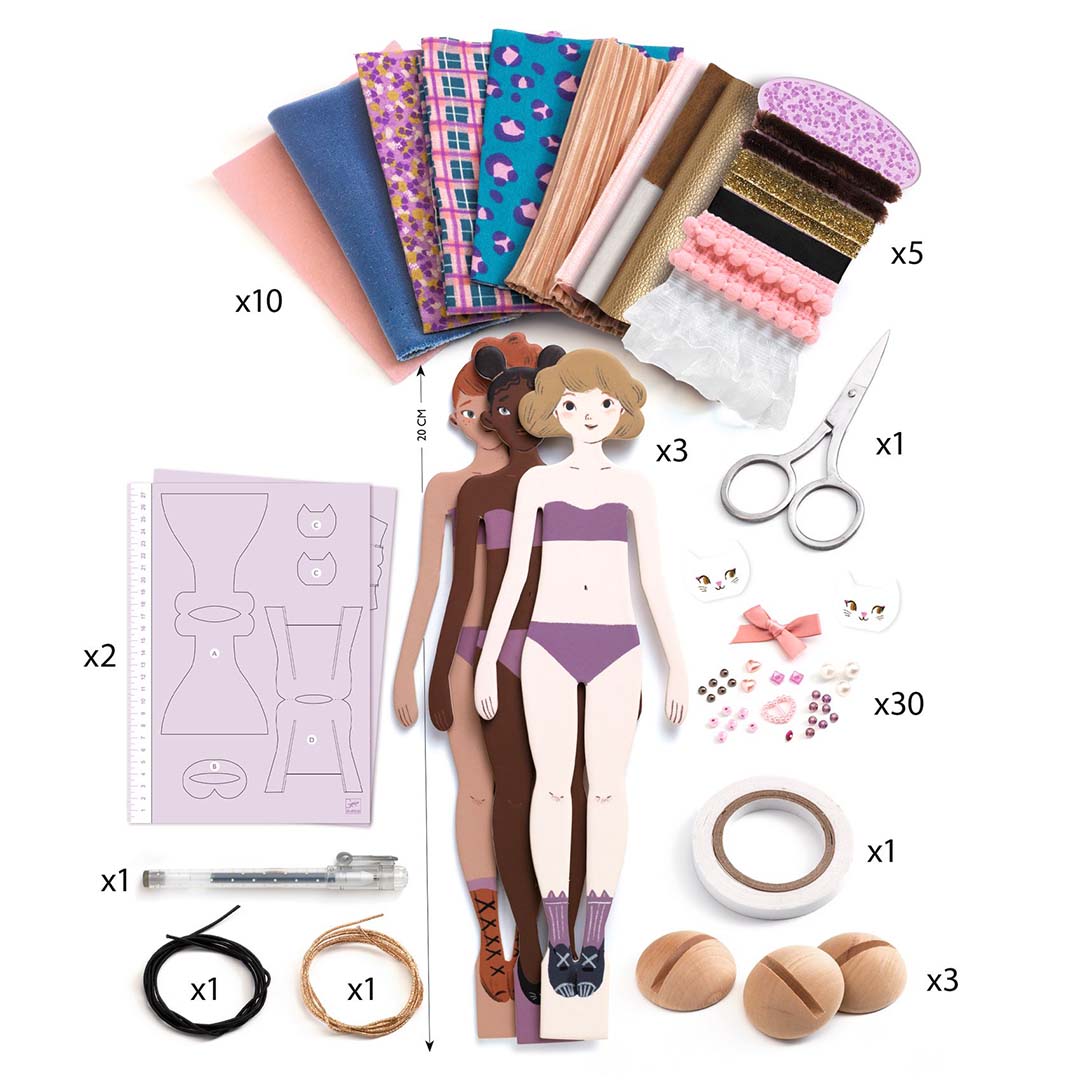 Overzicht van alle onderdelen van de Djeco knutselset 'La mode by Lucille', inclusief stoffen, poppen en accessoires.