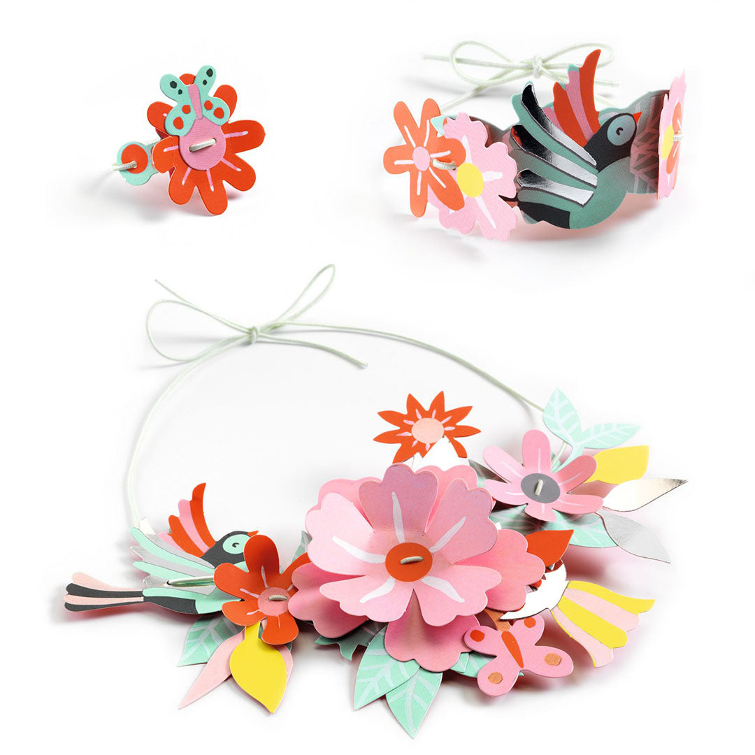 Drie gemaakte sieraden van de Djeco knutselset: een ketting, armband en ring met bloemen, bladeren en vogels.