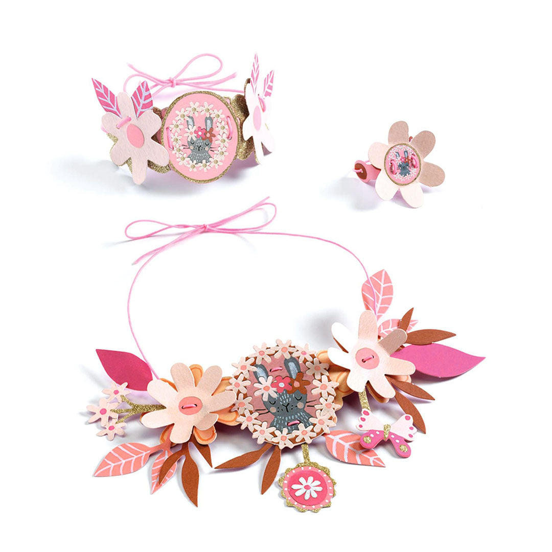 Een set van roze bloemen sieraden met een konijnenmotief, bestaande uit een ketting, armband en ring.