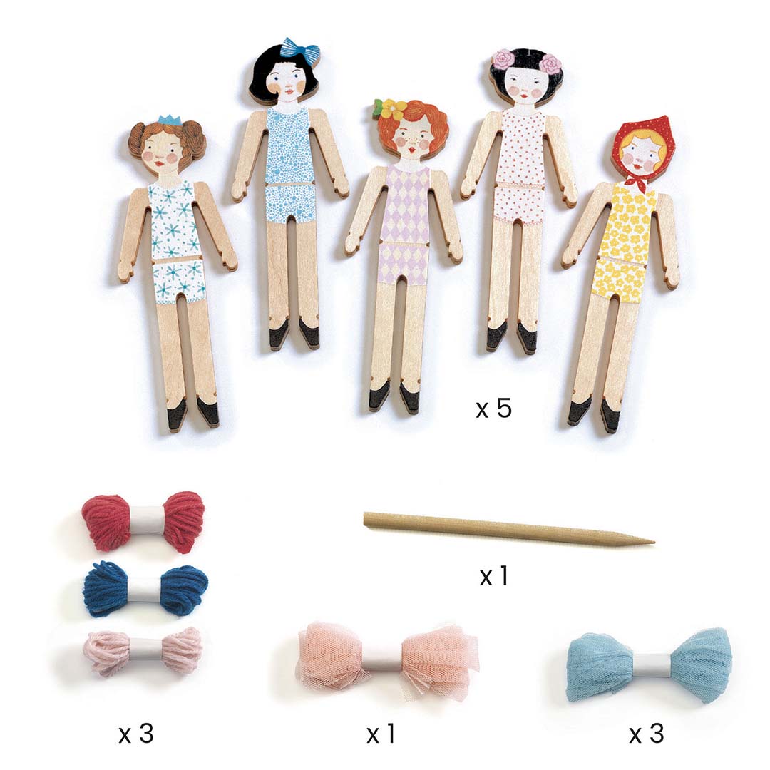 Alle onderdelen van de knutselset voor zorgenpoppetjes, met vijf houten poppetjes, garen en tule strikjes.