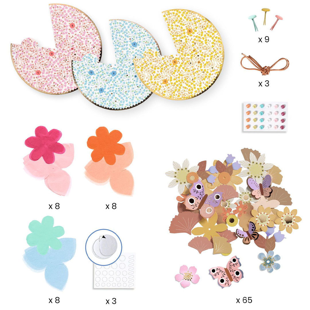 Alle onderdelen van de knutselset voor fascinator hoedjes, inclusief basisvormen, papieren bloemen, vlinders en decoraties.