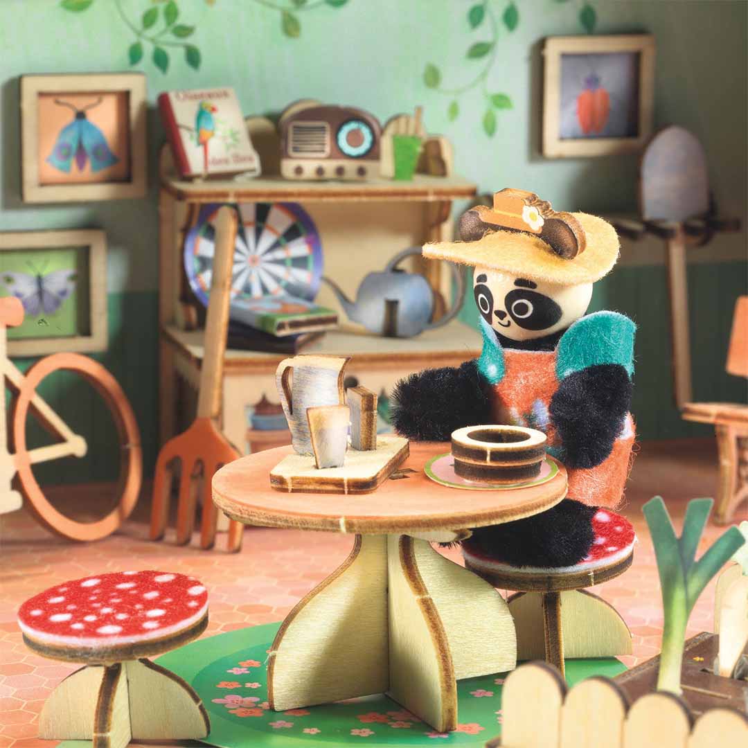 Detail van de Djeco knutselset 'Mi House - Olive' met een pandafiguur zittend aan een tafel in het huisje.