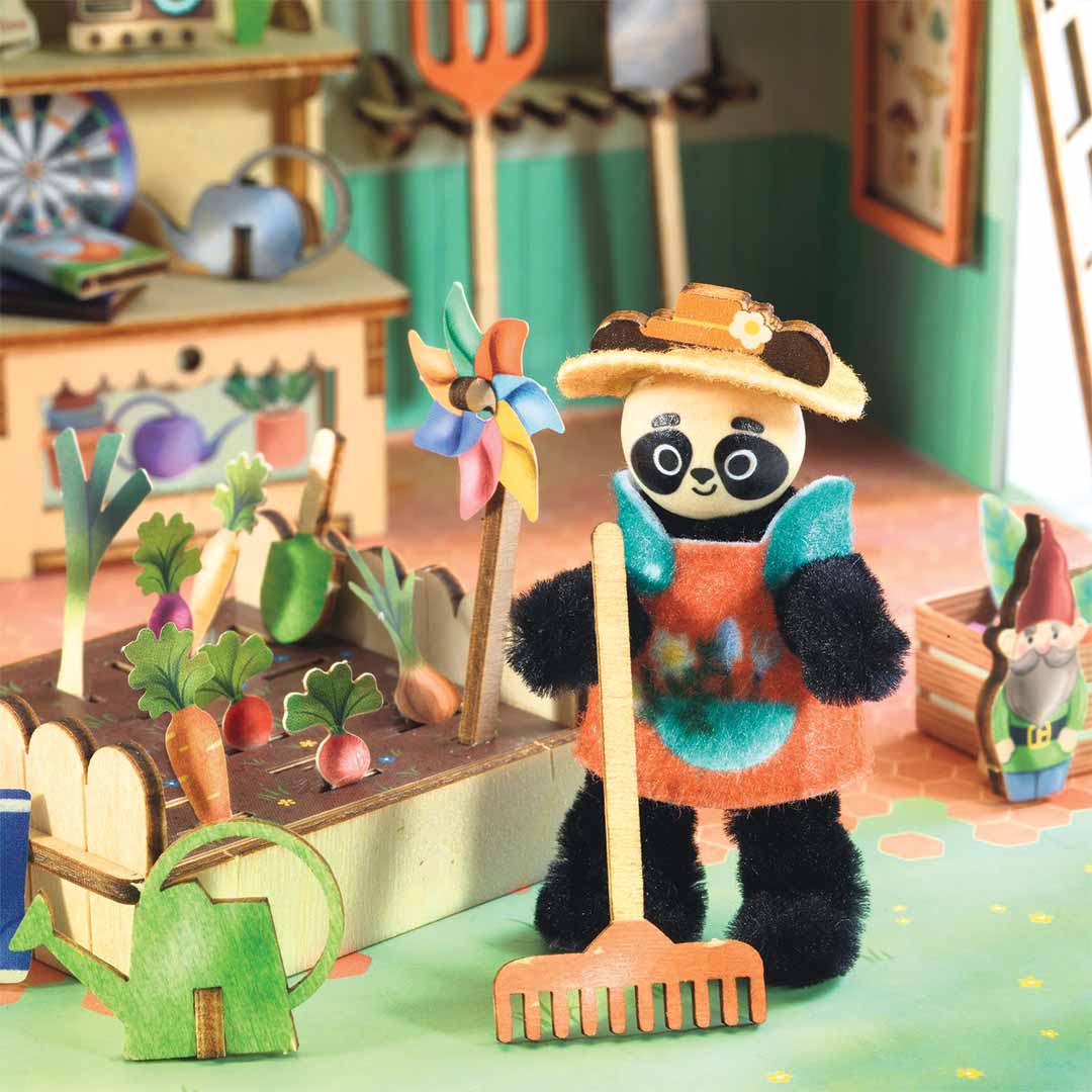 Detail van de Djeco knutselset 'Mi House - Olive' met een pandafiguur met hark naast een moestuinbakje met groenten.