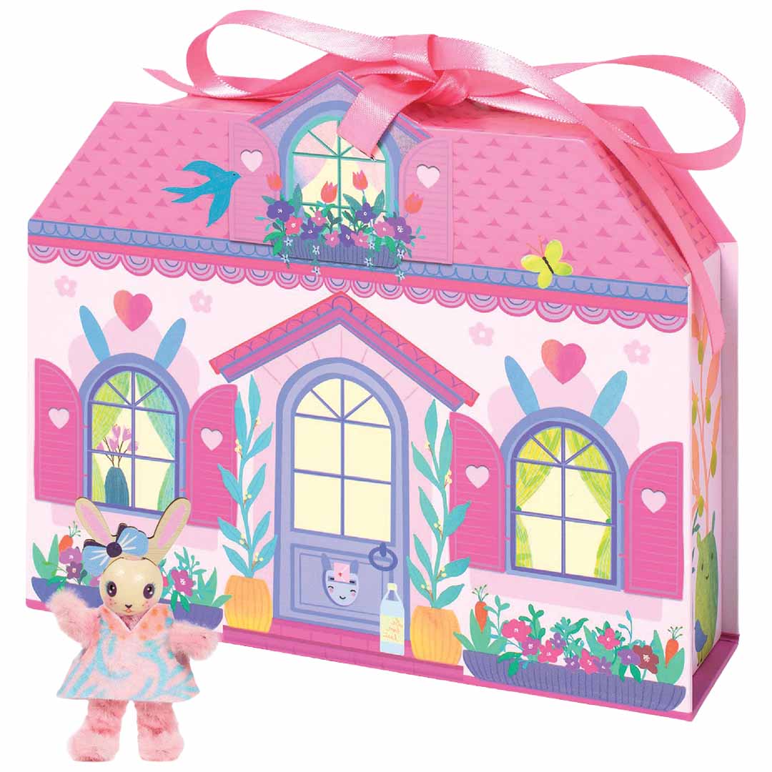 De roze huisvormige verpakking van de Djeco knutselset Mi House Rosie met een pluche konijn ervoor.