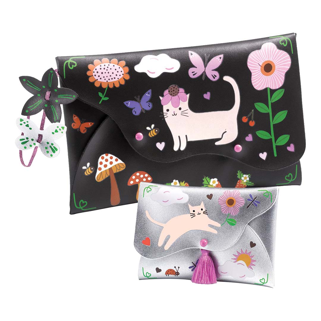 Twee gemaakte tassen en portemonnees van de Djeco knutselset, versierd met katten, bloemen en vlinders.