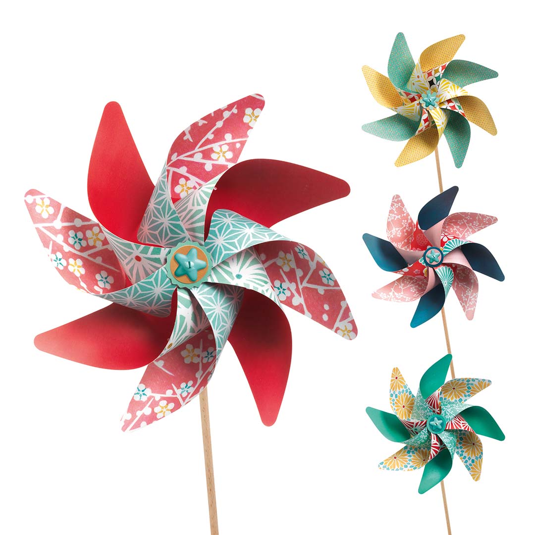 Vier geassembleerde Djeco knutsel windmolentjes met verschillende bloem- en geometrische patronen.