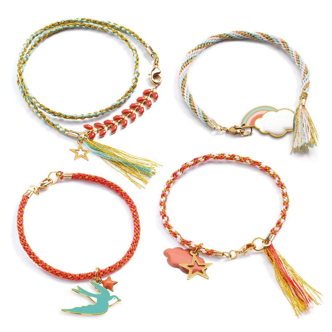 Vier verschillende Djeco Kumihimo armbandjes met bedeltjes van sterren, een vogel, een regenboogwolk en bladeren.