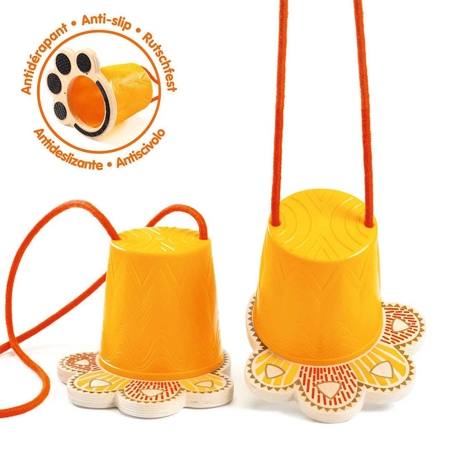 Twee gele Djeco loopklossen met oranje touwen en een anti-slip zool in de vorm van een dierenpoot.