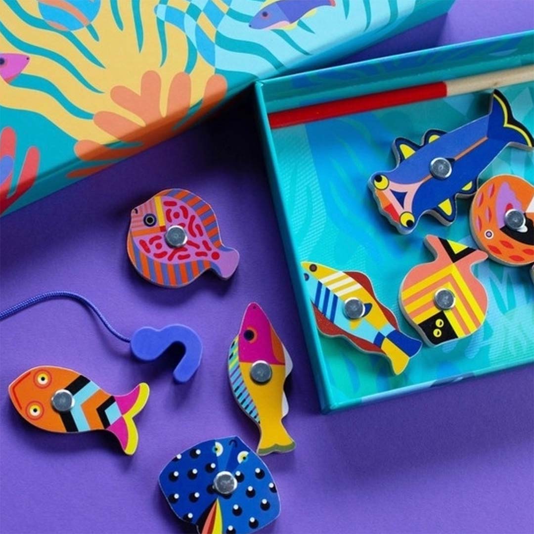 Detailfoto van het Djeco magnetisch visspel met kleurrijke houten tropische vissen en een hengelhaak op een paarse ondergrond.