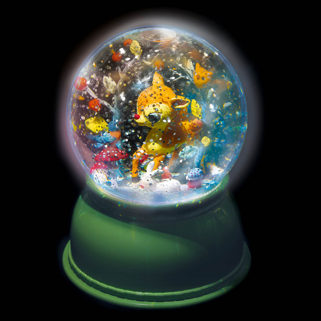 Het Djeco nachtlampje met hertje en dieren in het donker, verlicht en met zwevende glitters.