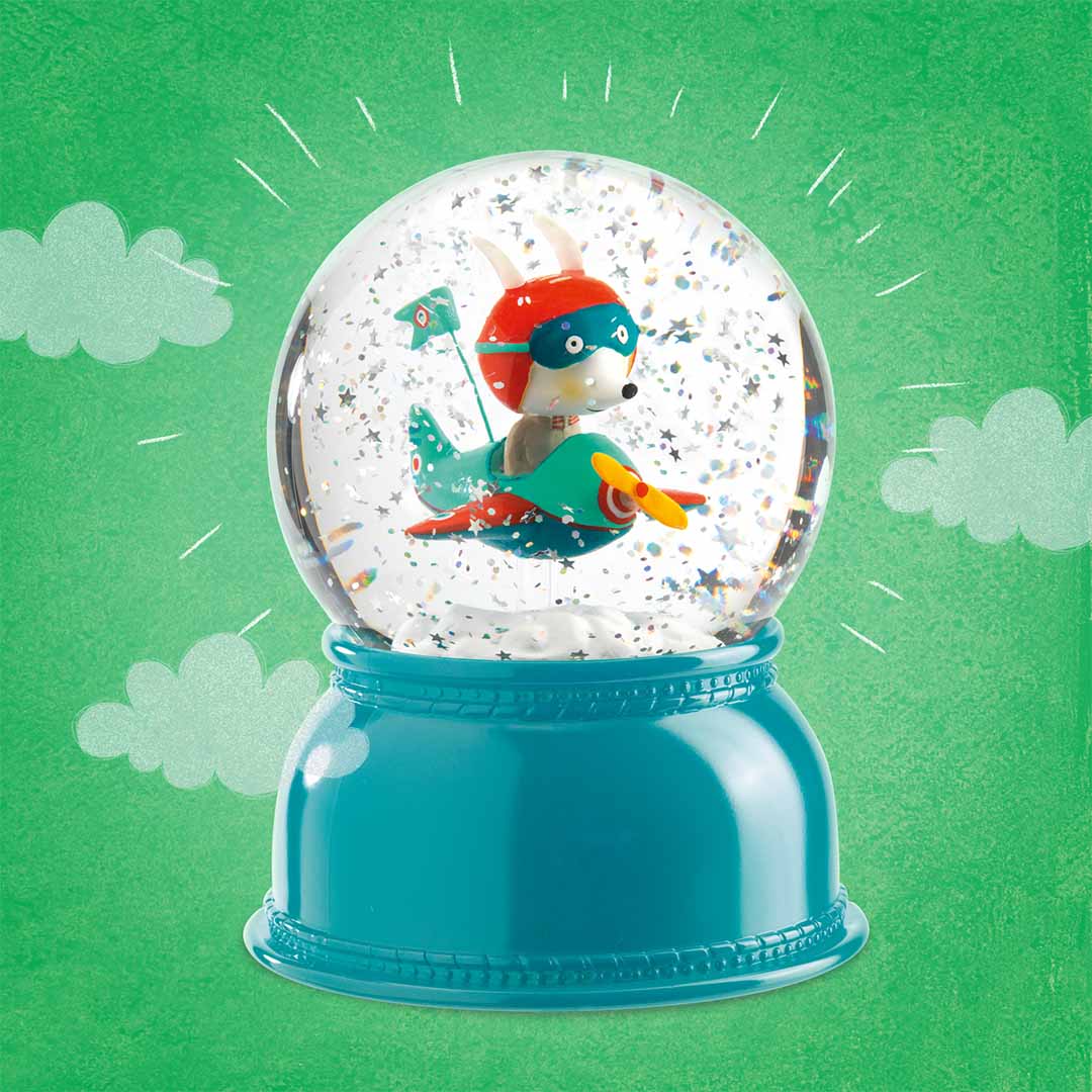 Het Djeco nachtlampje sneeuwbol met een vliegend dier in een vliegtuigje op een groene achtergrond met wolken.