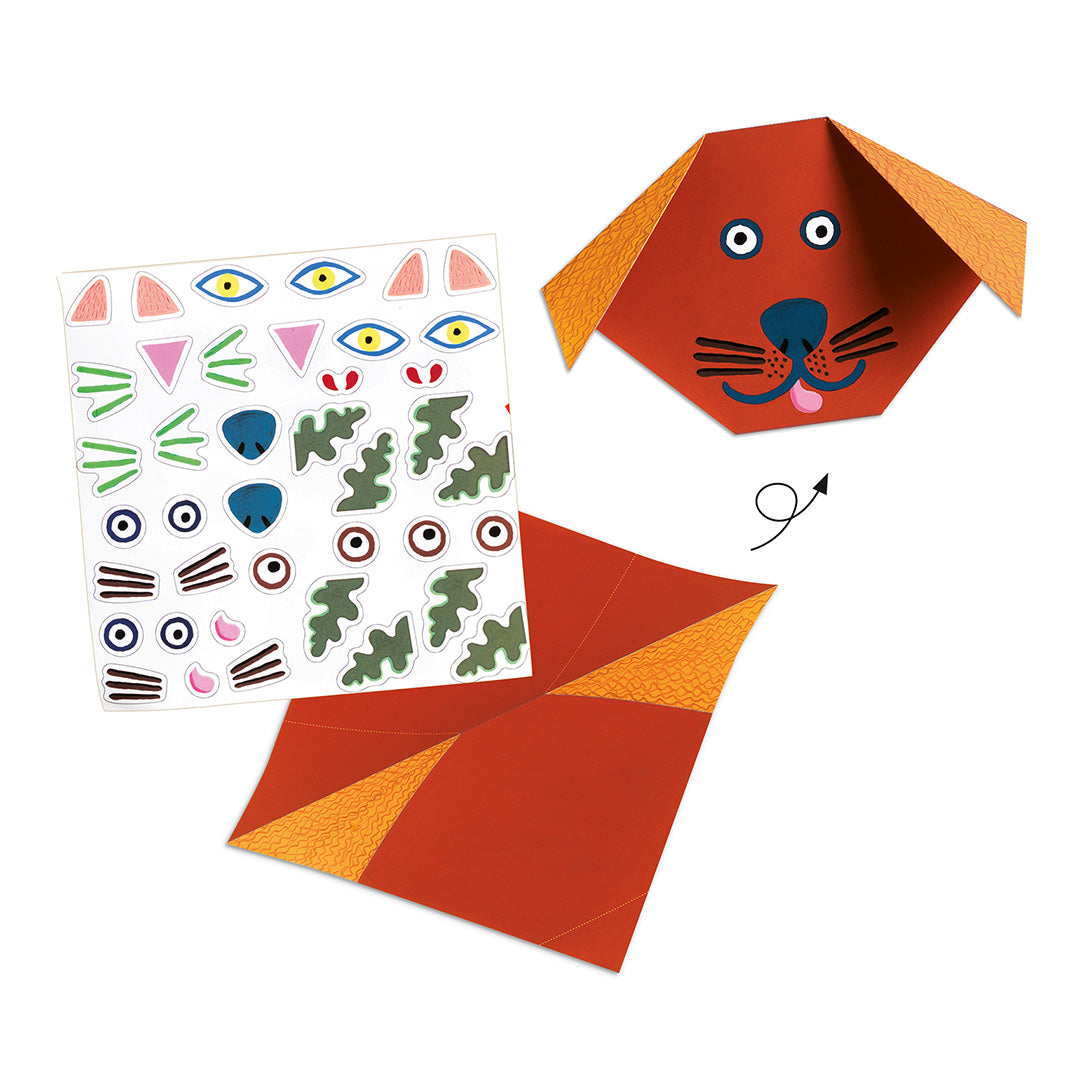 Detail van de Djeco origami hobbyset met een gevouwen hondenhoofd, een vel met stickers voor ogen en neuzen, en een stuk vouwpapier.