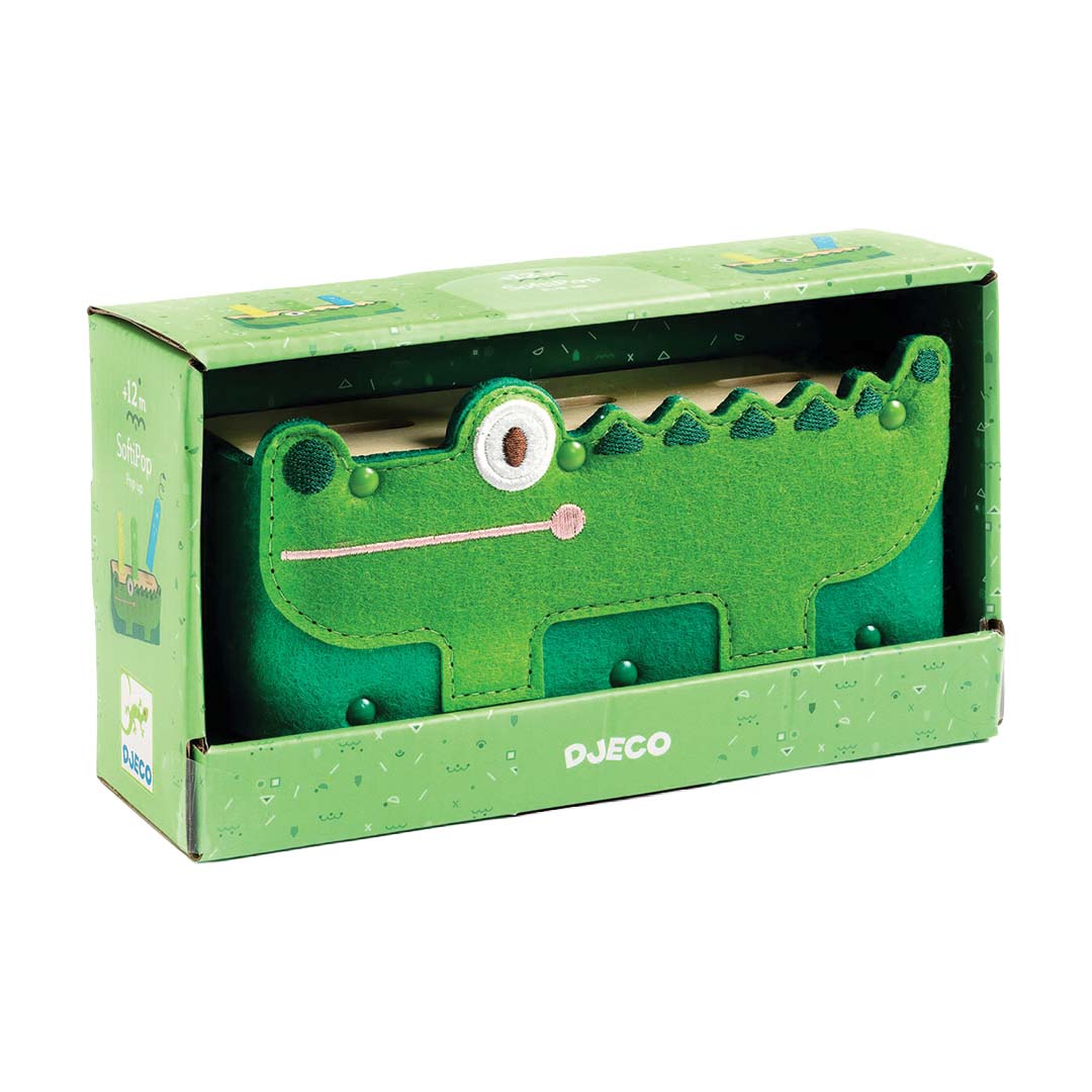 De Djeco pop-up krokodil babyspeeltje in de groene productverpakking.