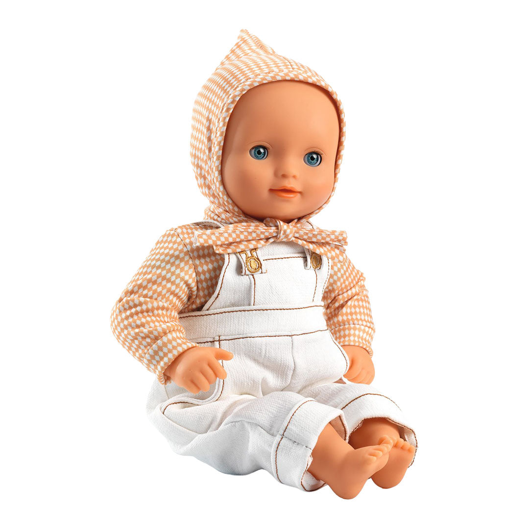 Een pop met blauwe ogen draagt de Djeco poppenkledingset bestaande uit een witte tuinbroek, oranje geruit shirt en muts.