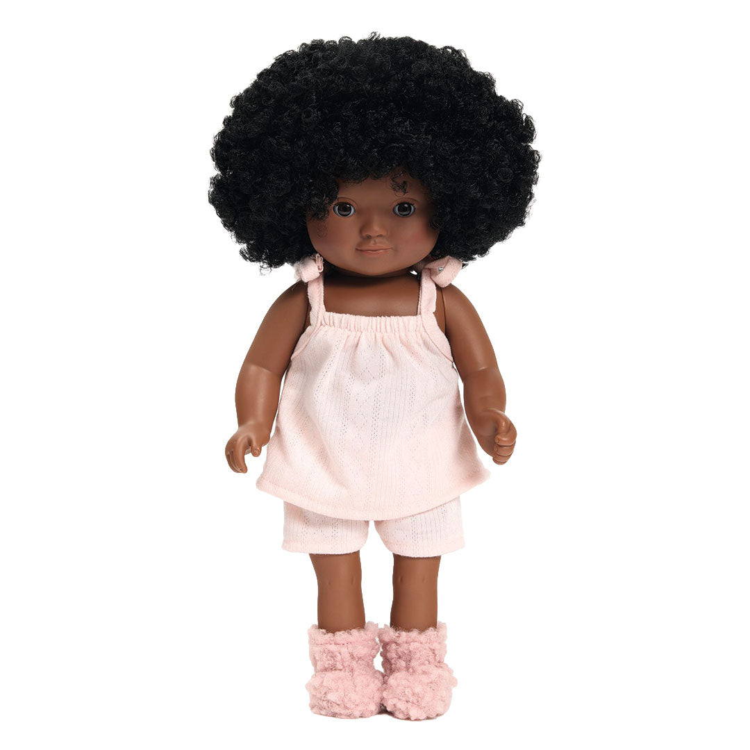 Een donkere pop met afro draagt de Djeco Pomea Lovely roze poppenkledingset.