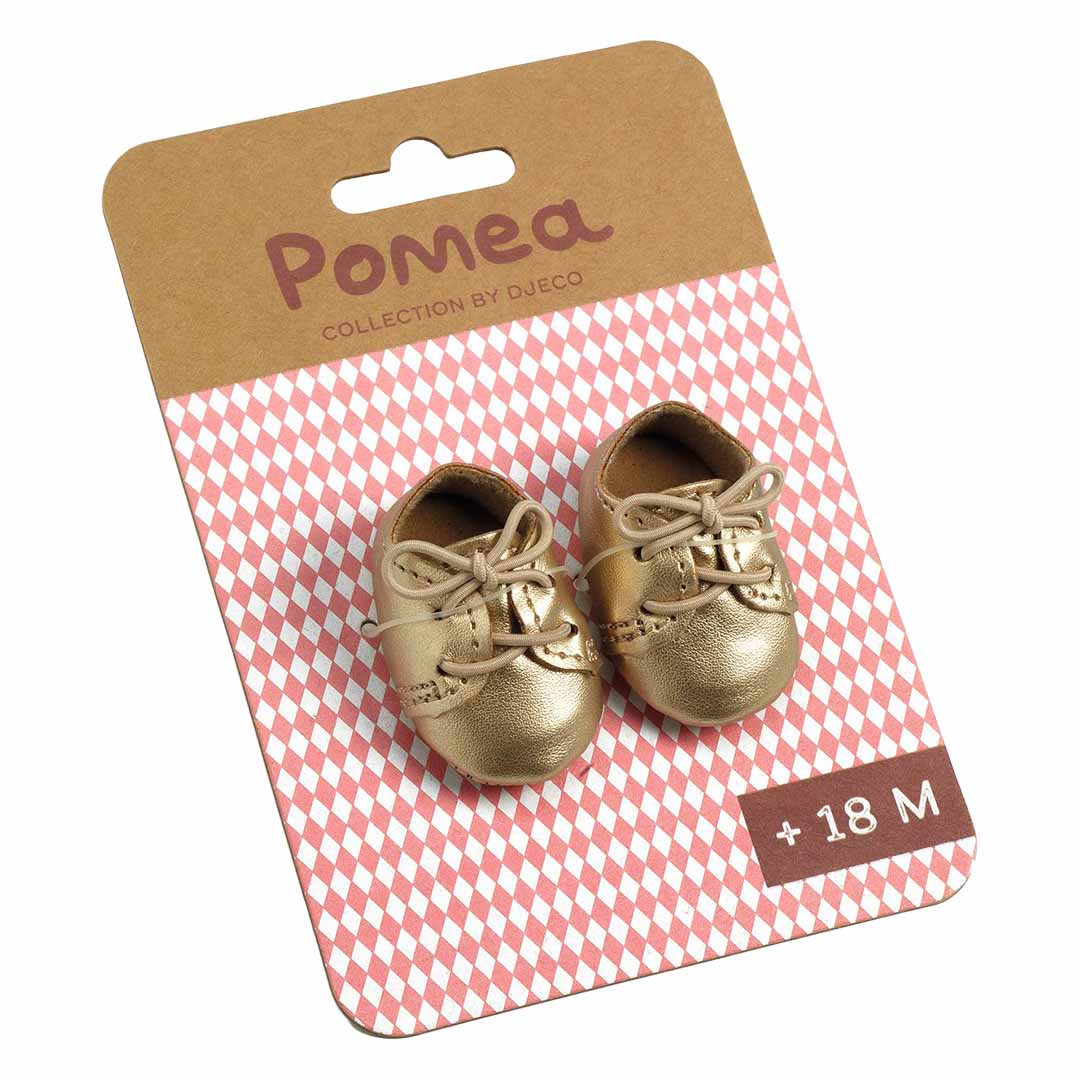 De Djeco Pomea gouden poppenschoenen op hun kartonnen verpakking.