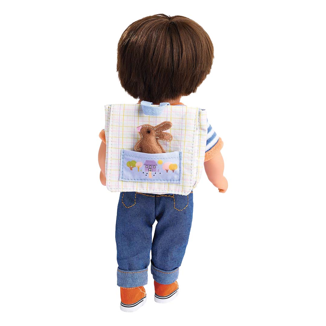 Een pop met bruin haar draagt de Djeco Pomea poppenschooltas met geruit patroon en vilten konijntje op de rug.