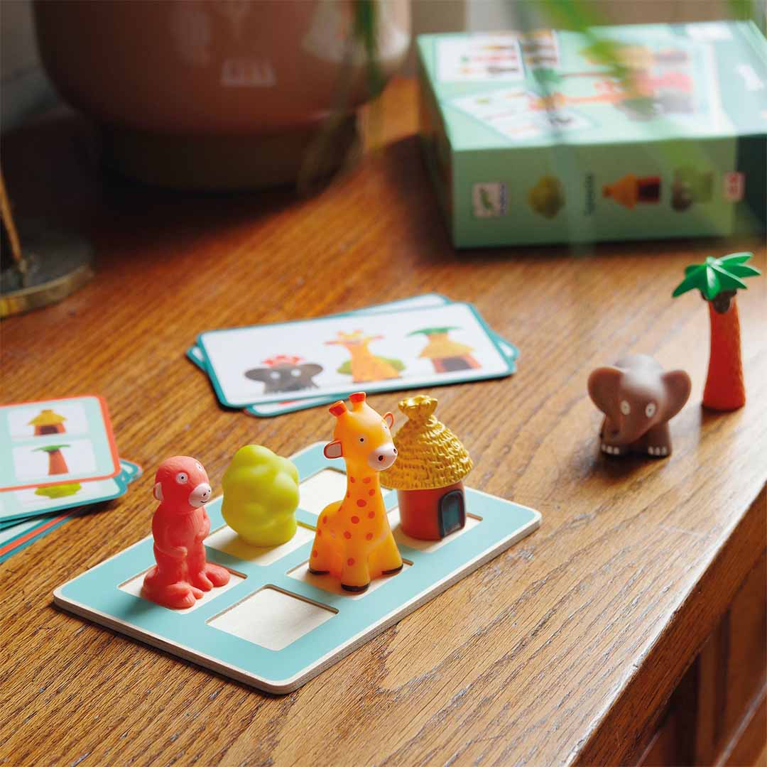 Djeco educatief bordspel Spacio met safari dierenfiguren en speelkaarten op een houten tafel.
