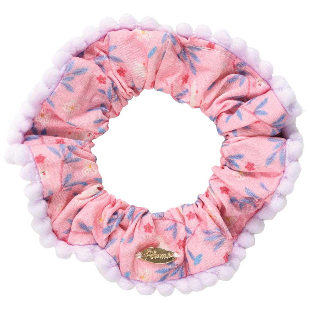 Djeco roze gebloemd haarelastiek met paarse pomponrand.