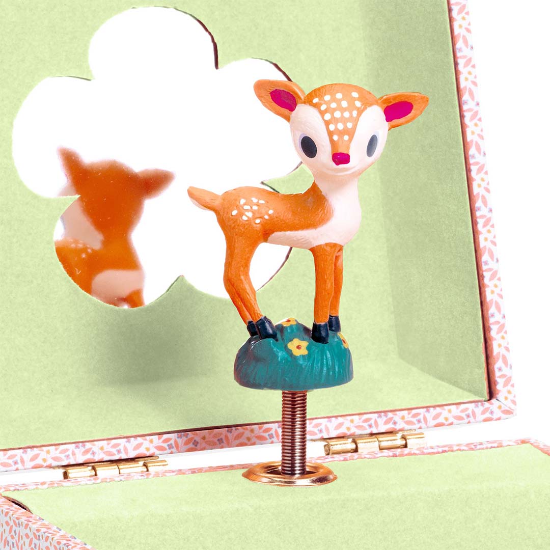 Close-up van de ree figurine in het Djeco muziekdoosje met spiegelreflectie.