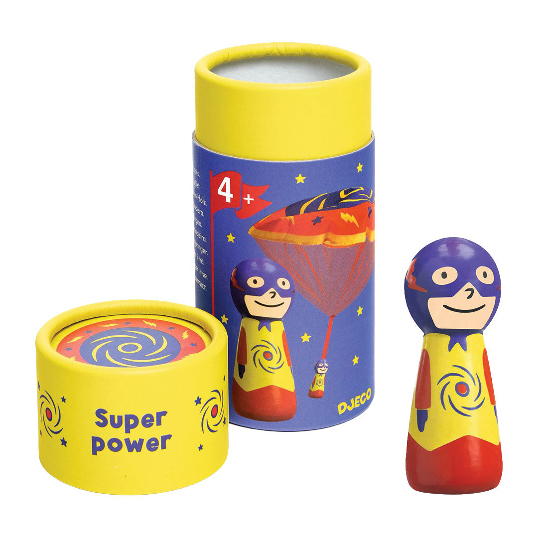 De Djeco speelfiguur parachutist super power in de verpakking, met de houten superheldenfiguur ernaast.
