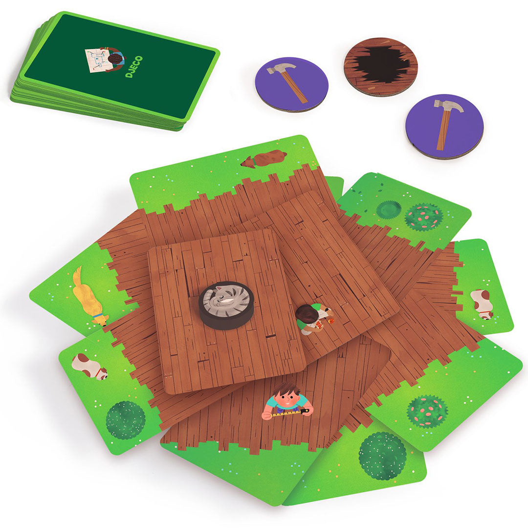 Djeco Cabana Boom spelonderdelen met groene kaarten, houten fiches en speelstukken die een boomhut voorstellen.