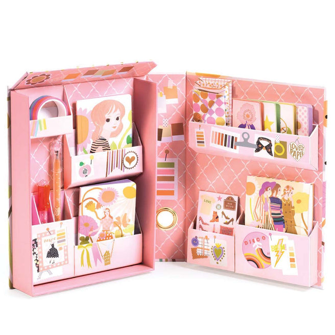 Een open roze Djeco stationery box, gevuld met diverse schrijfwaren en decoraties in mode- en bloementhema.