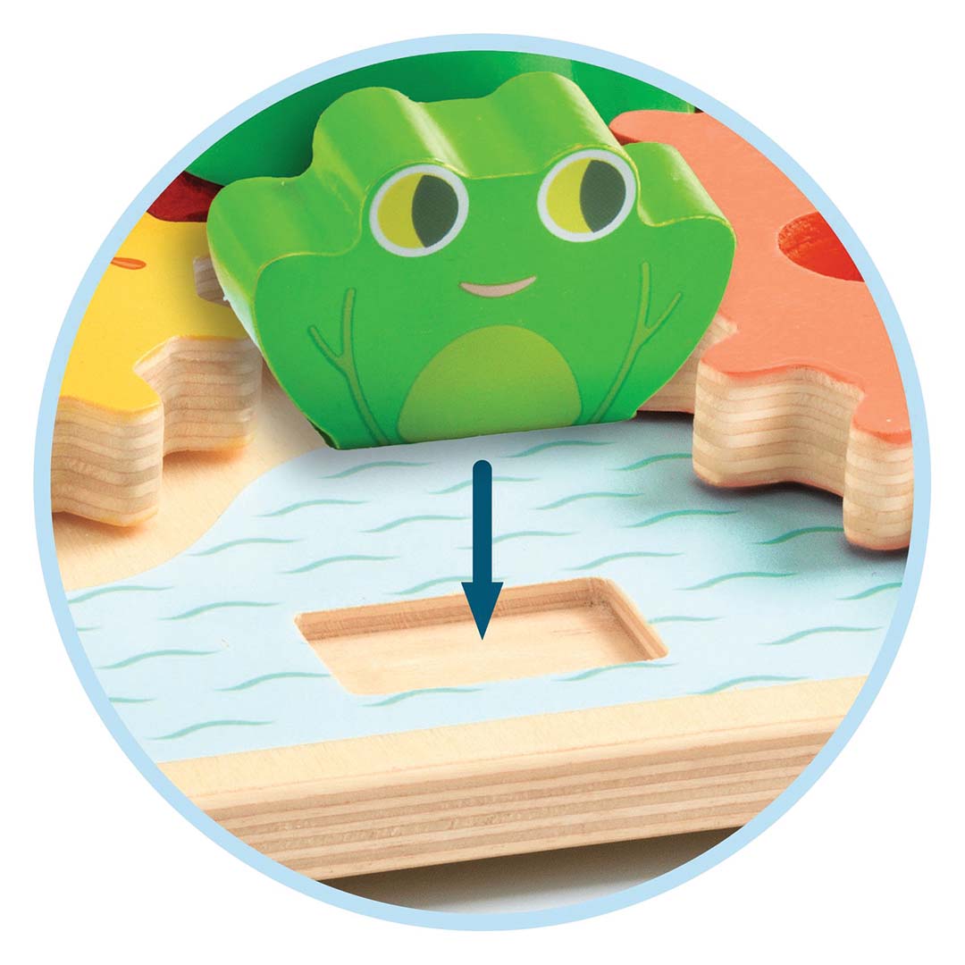 Detail van het houten tandwielspel met een groene kikker die in een uitsparing op de basis wordt geplaatst.