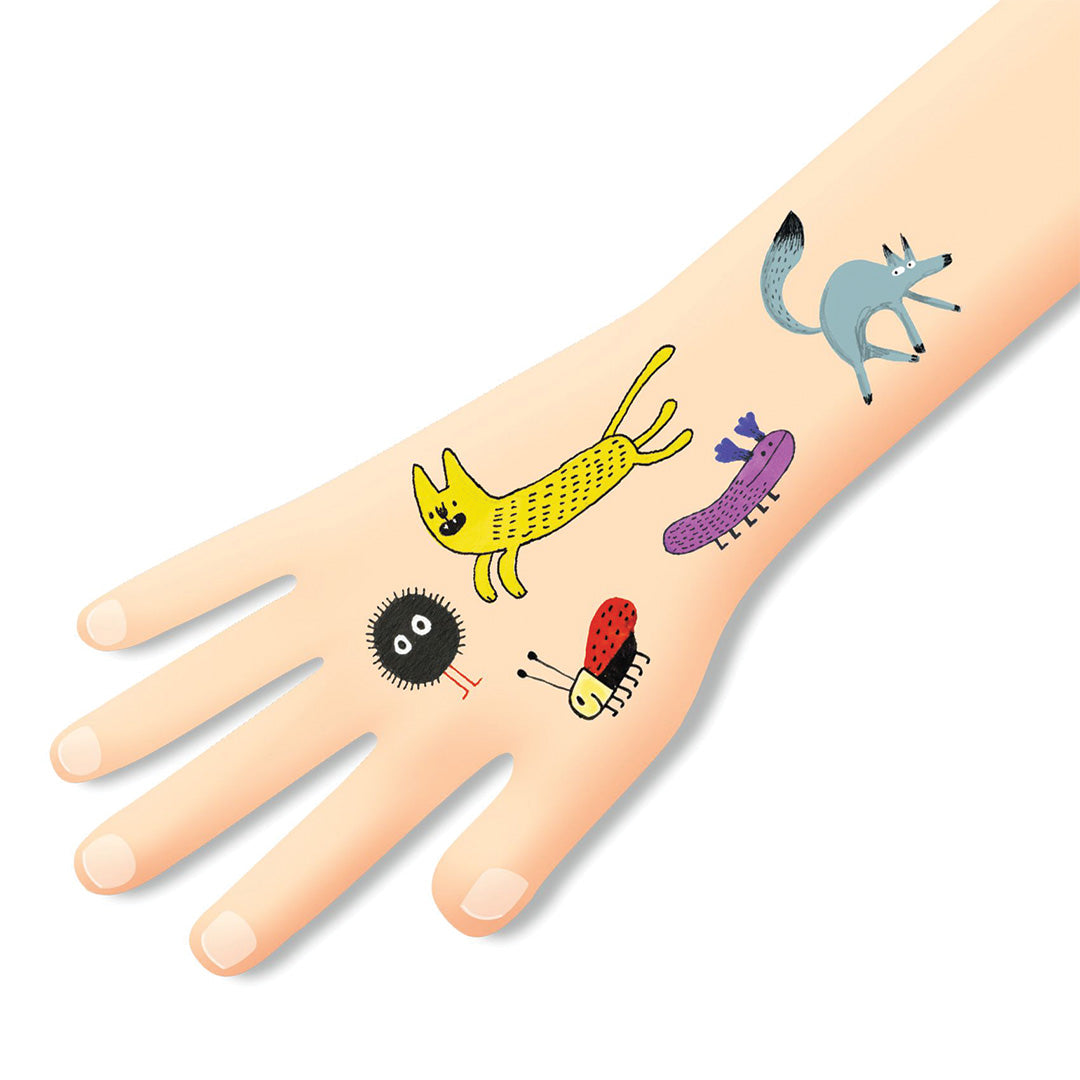 Djeco tijdelijke tatoeages van een gele kat, rode lieveheersbeestje en andere dieren op een kinderarm.