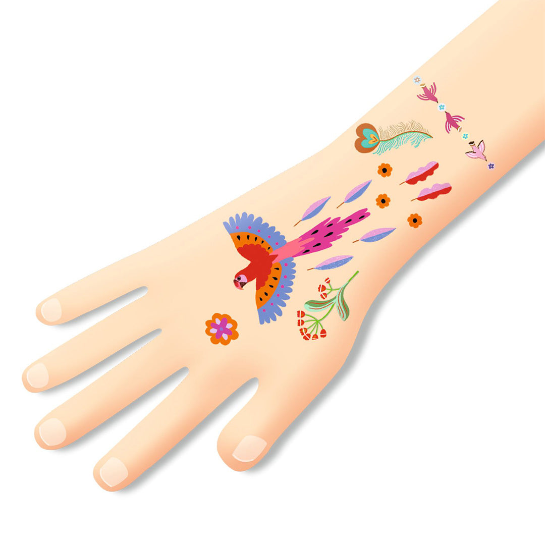 Een hand met daarop aangebrachte tijdelijke tattoos van een kleurrijke vogel, veren en bloemen.
