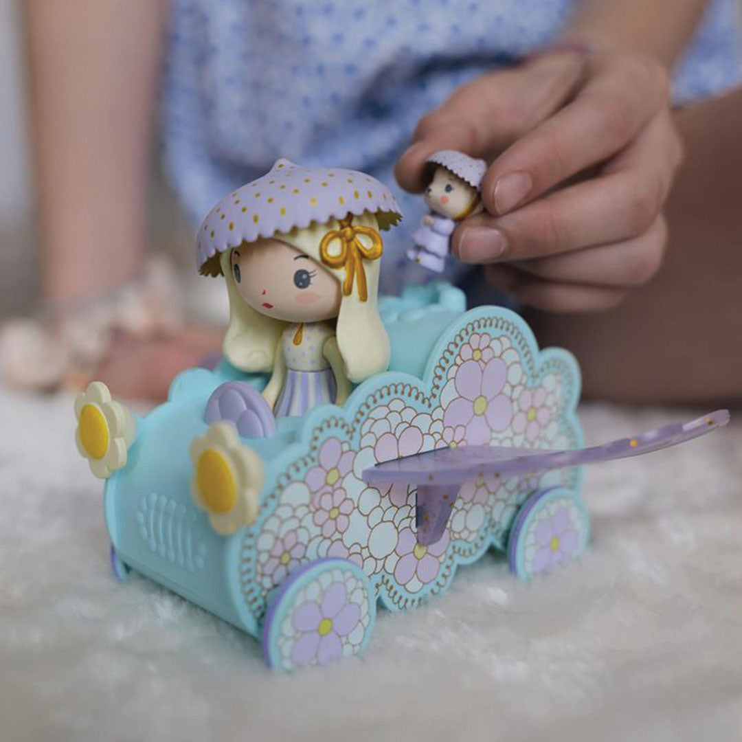 Een kinderhand plaatst de kleine Jerry tinyly speelfiguur in de lichtblauwe auto naast Jil.