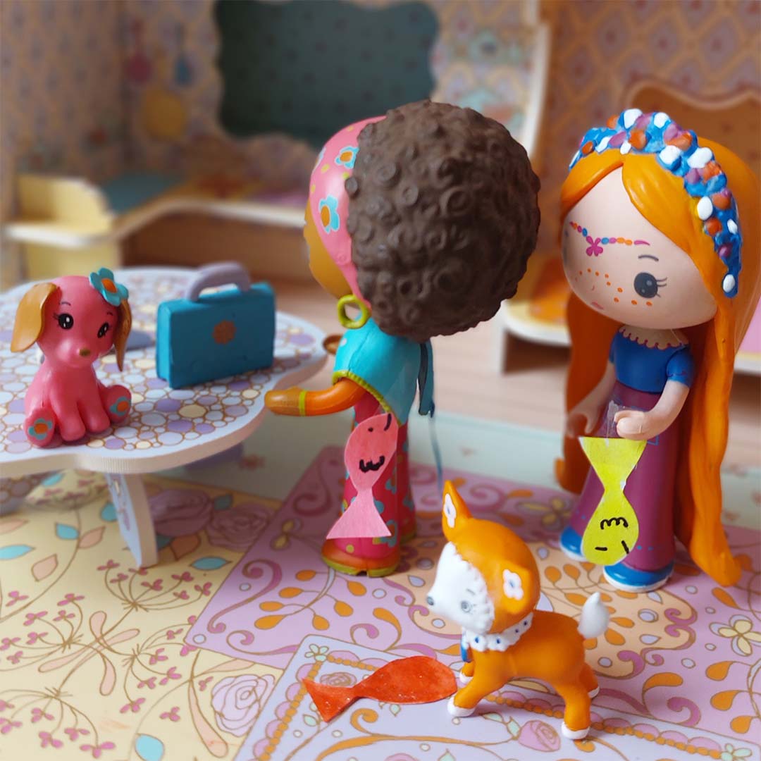 Djeco Tinyly speelfiguren Poppy en een roodharig figuur met hun hondjes in een speelgoedhuis.