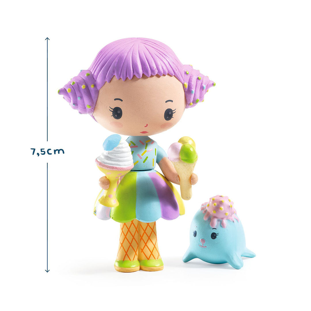 Djeco Tinyly speelfiguur van een meisje met paars haar en twee ijshoorntjes, naast een blauw zeehondje, met een hoogteaanduiding van 7,5 cm.