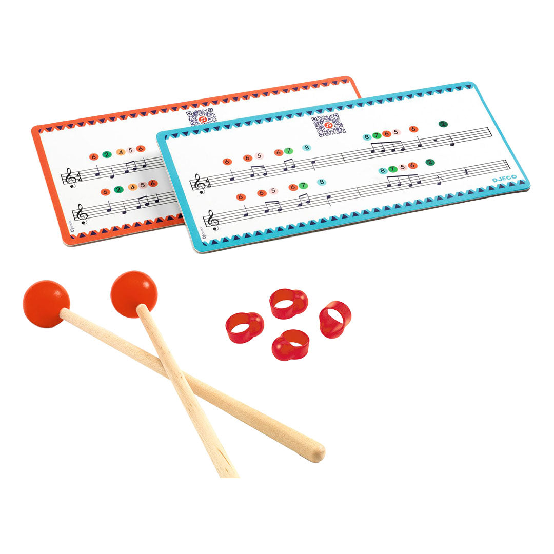 Djeco accessoires voor muziekspeelgoed met twee drumstokken, vier rode vingerringen en twee muziekkaarten.