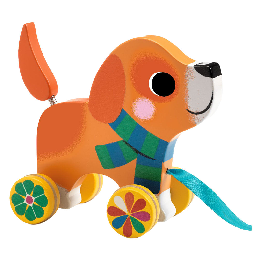 Djeco houten trekfiguur hond Lou met oranje lijf, gestreepte sjaal en bloemwielen.