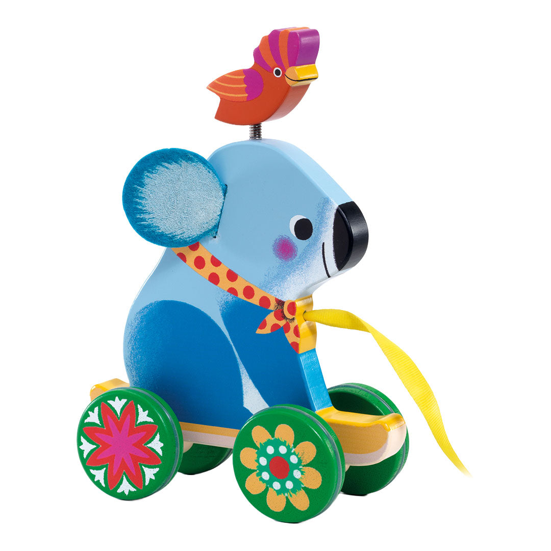 Djeco houten trekfiguur van een blauwe koala met een vogel op zijn hoofd en bloemige wielen.