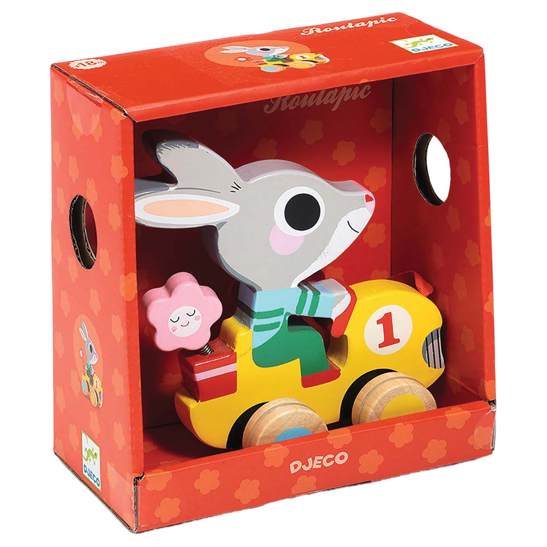 De Djeco houten trekfiguur van een konijn in een gele raceauto, in de rode productverpakking.
